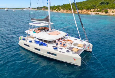 Vista drone del Lagoon 55 "Strafico" della flotta SAILUXE ancorato a Tavolara, in Sardegna con crew in piedi a prua